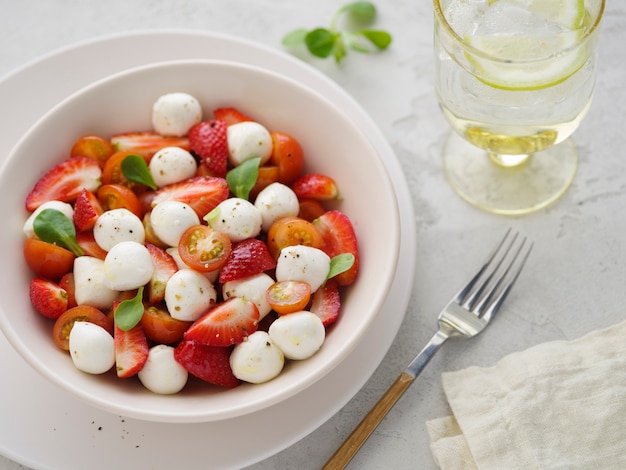 Salad with mozzarella, strawberries, and cherry tomatoes