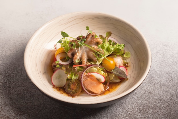 Salad with octopus, radish, lettuce, micro greens, red fish and cherry