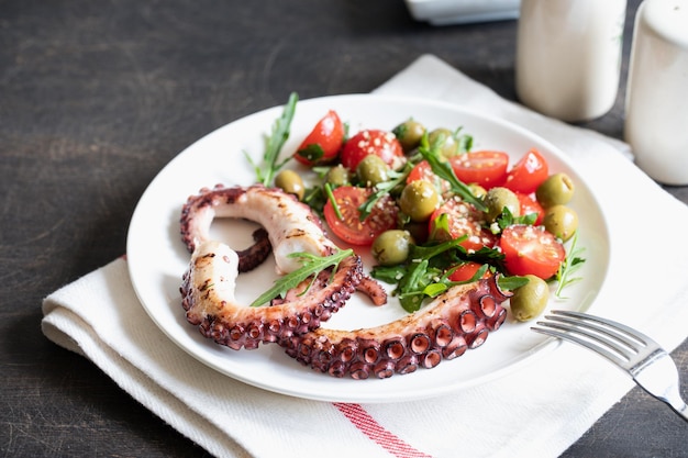 Photo salad with octopus tomatoes olives and arugula fresh healthy salad