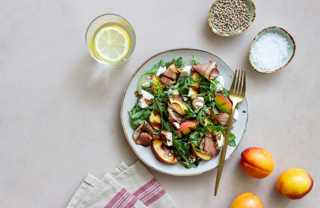 Insalata con pesche, rucola, formaggio e jamon. mangiare sano.