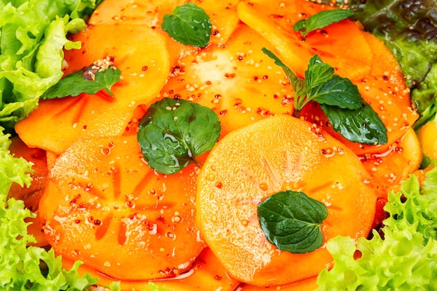 Salad with persimmons and lettuce leaves