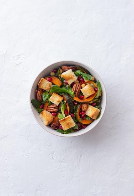 Salad with pumpkin, pomegranate, pecans and croutons. Healthy eating. Vegetarian food.