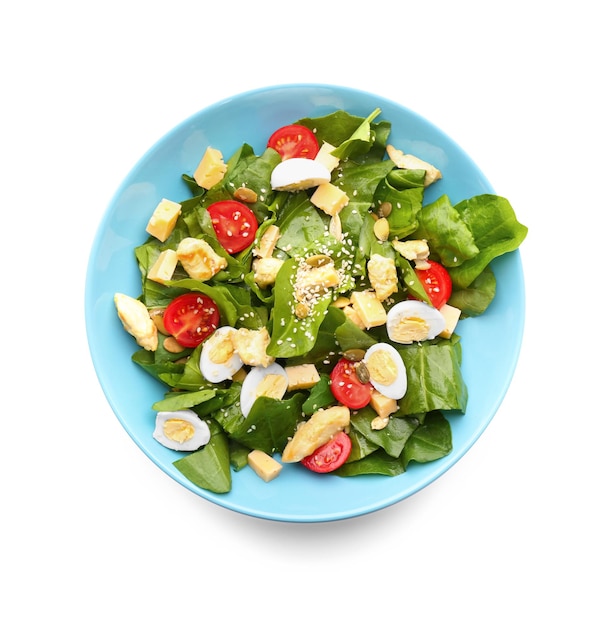 Salad with quail eggs and spinach in plate isolated on white