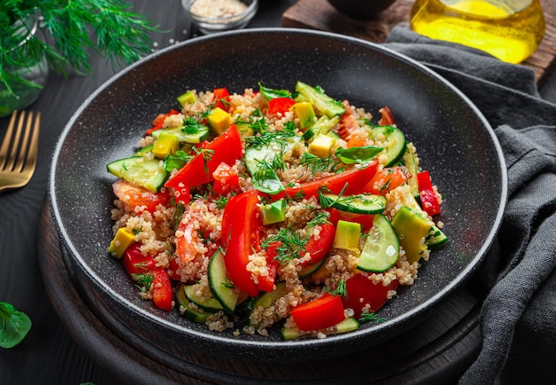 어두운 배경에 퀴노아 아보카도 토마토와 오이 샐러드 채식 건강 샐러드 측면보기 근접 촬영