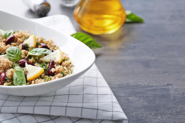 Salad with quinoa basil and beans served in bowl on grey background