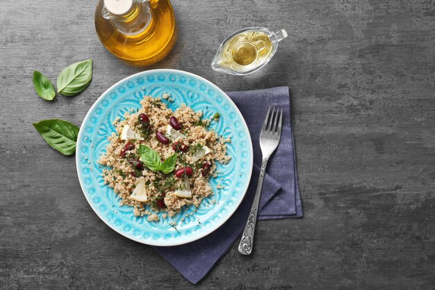 Salad with quinoa basil and beans served on grey background