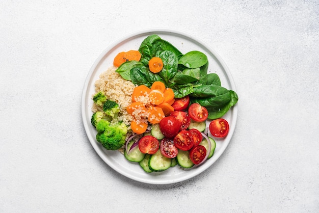 Salad with quinoa spinach broccoli tomatoes cucumbers and carrots