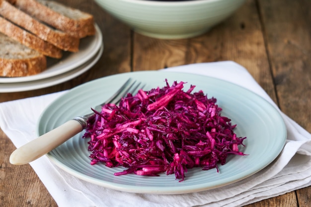 Salad with red cabbage and apples on wooden