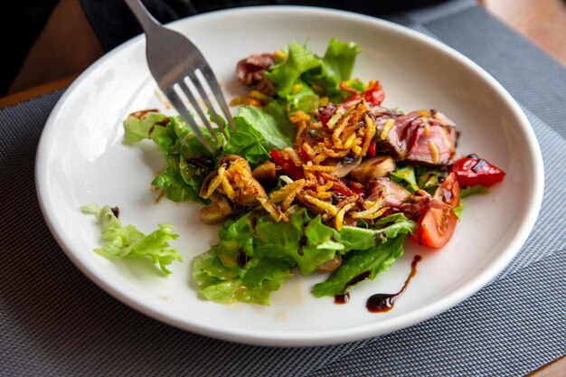 Salad with roast beef in a white plate Traditional cuisine