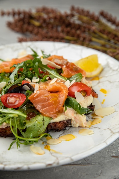 Foto insalata con caviale di salmone erbe ciliegie su un tavolo di pietra bianca in un ristorante