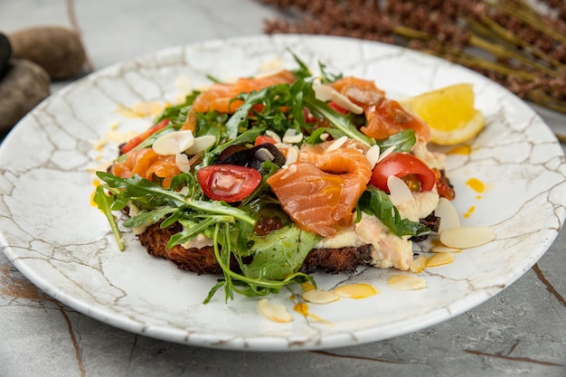 Salad with salmon caviar herbs cherries On a white stone table in a restaurant