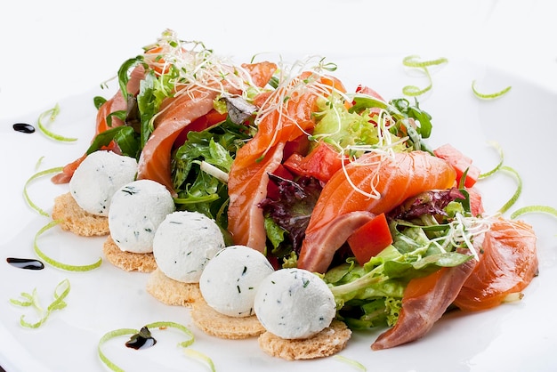The salad with salmon and cottage cheese balls on a white background
