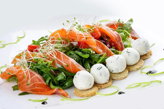 The salad with salmon and cottage cheese balls on a white background