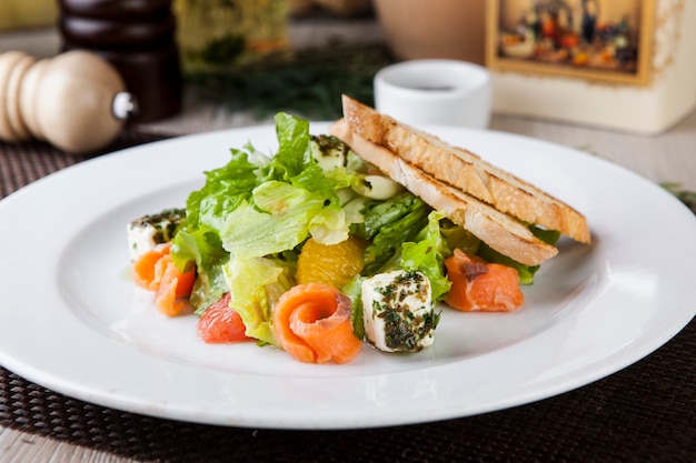 salad with salmon herbs cheese and toast in sauce