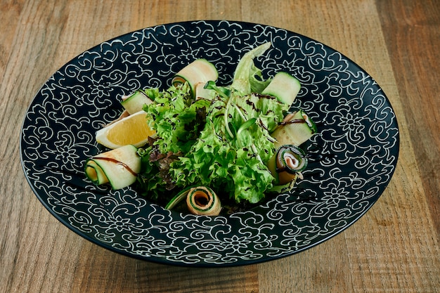 Salad with salmon, mix of leaves, cherry tomatoes and avocado in white bowl. Useful and healthy food.