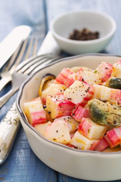 Salad with seafood in bowl on wooden table