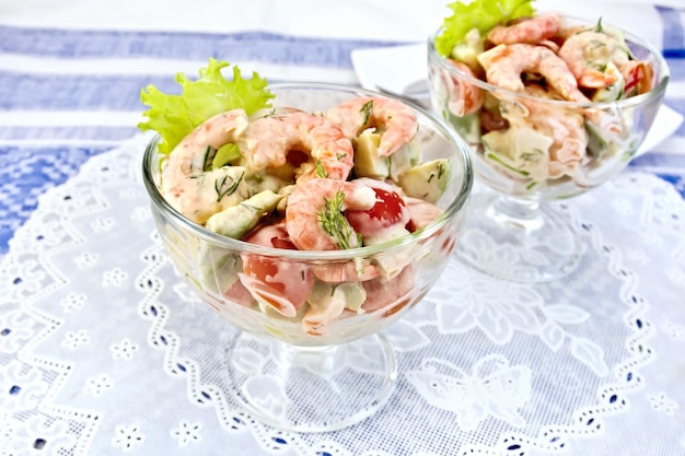 Salad with shrimp and tomatoes in glass on napkin silicone