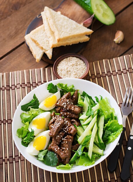 Salad with spicy beef, cucumber and eggs in the Asian style.