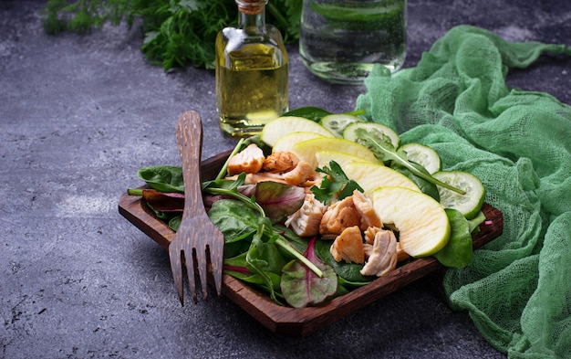 Salad with spinach, chicken, cucumber and apple. Selective focus