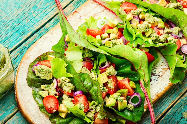 Salad with tomato,avocado,garlic sauce in chard leaves.Summer vitamin salad on kitchen board