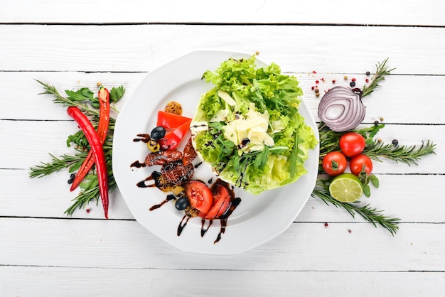 Salad with tomatoes arugula and smoked tomatoes On a wooden background Top view Copy space