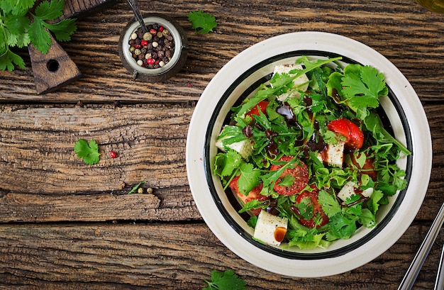 Photo salad with tomatoes, cheese and cilantro in sweet and sour sauce. georgian cuisine.