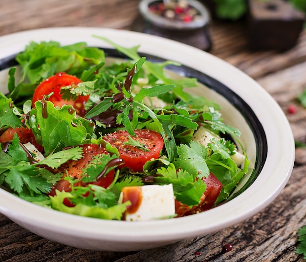 Foto insalata con pomodori, formaggio e coriandolo in salsa agrodolce