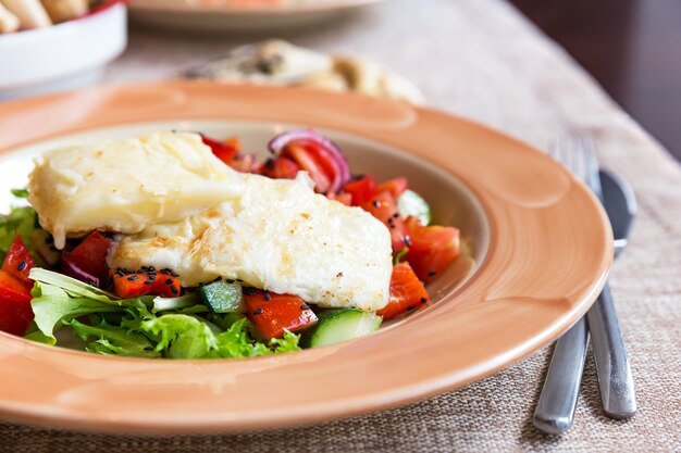 Salad with tomatoes onions cucumbers and fried cheese suluguni