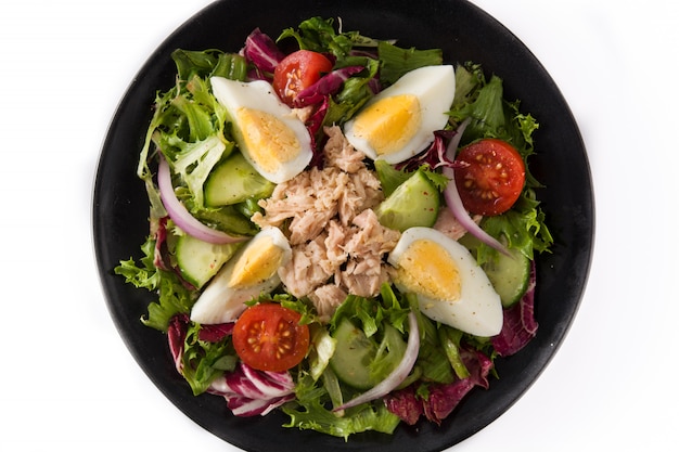 Salad with tuna, egg and vegetables on white close up