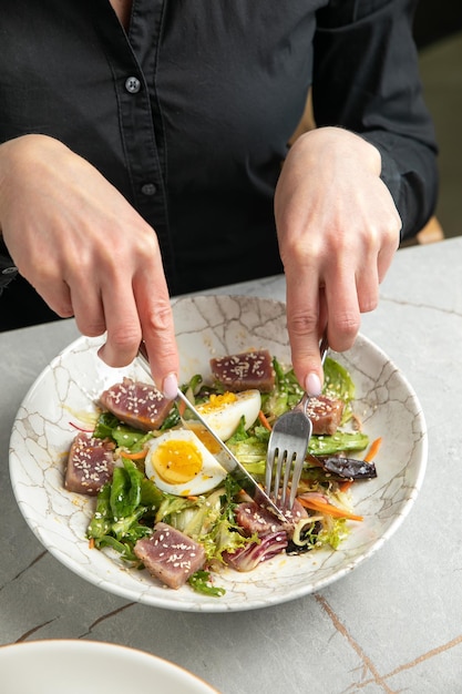 salad with tuna lettuce herbs egg on a gray table