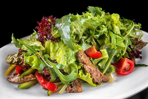 Salad with veal herbs and tomatoes on a plate