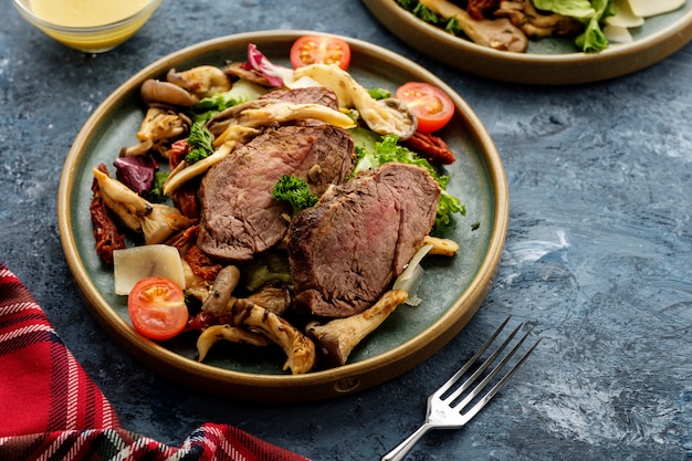 Insalata di manzo tiepida con funghi ostrica, pomodori e verdure.