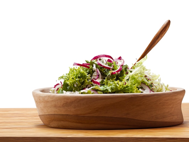 Foto insalata in ciotola e cucchiaio di legno