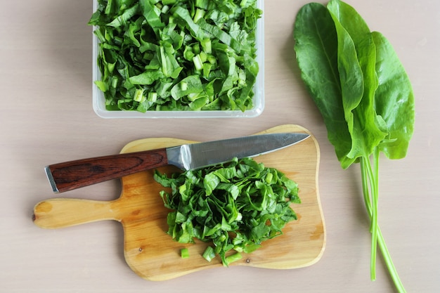 Salade gesneden op snijplank en mes op tafel