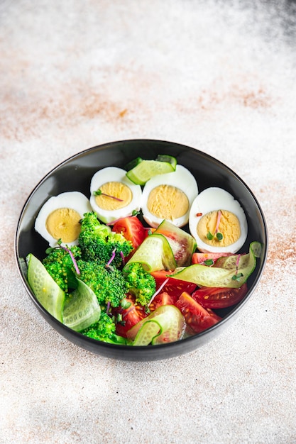 Salade groenten en ei broccoli tomaat komkommer maaltijd snack op tafel