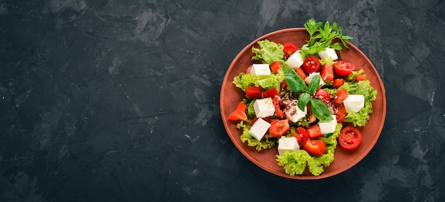 Salade in een bord Feta kaas cherrytomaatjes paprika sla Gezond eten Op de stenen tafel Bovenaanzicht Vrije ruimte voor tekst