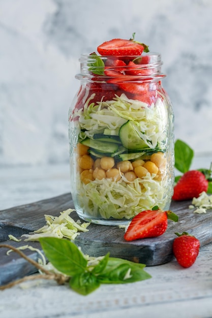 Salade met aardbeien en kikkererwten in een pot