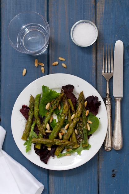 Salade met ansjovis en ui op witte plaat op blauwe oppervlakte