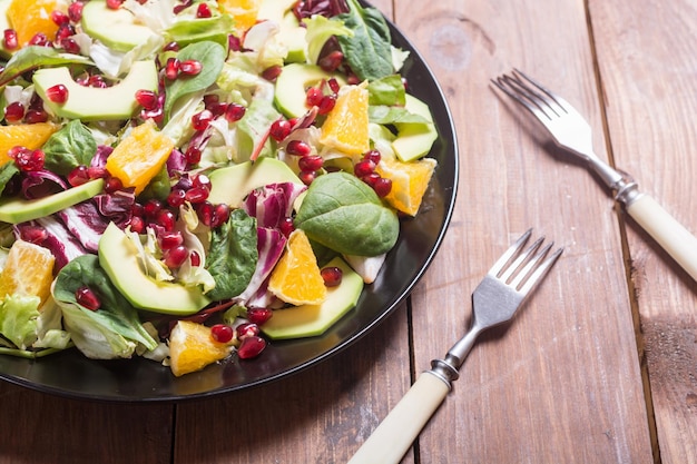 Salade met avocado-sinaasappelspinazie en granaatappel