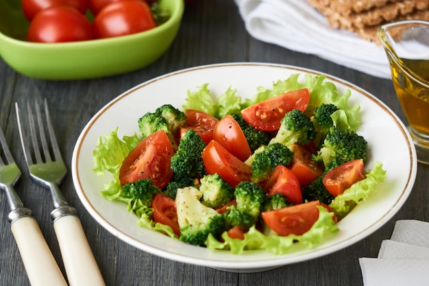 Salade met broccoli en kersentomaten in een witte kom