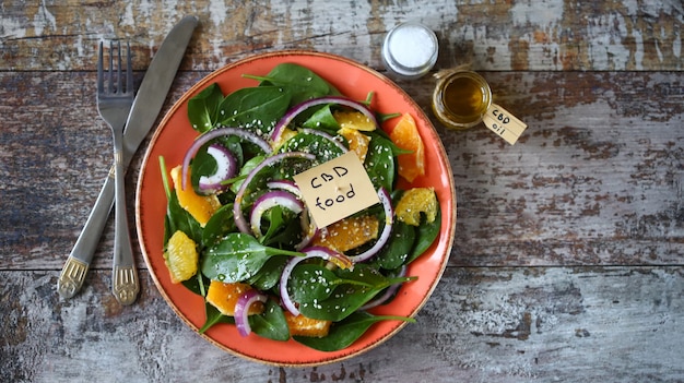 Salade met cannabisolie. Gezonde salade met spinazie en sinaasappel.