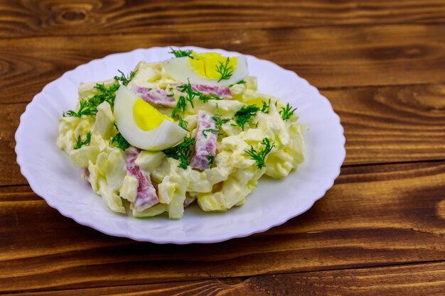 Salade met chinese kool ui worst eieren en mayonaise op houten tafel