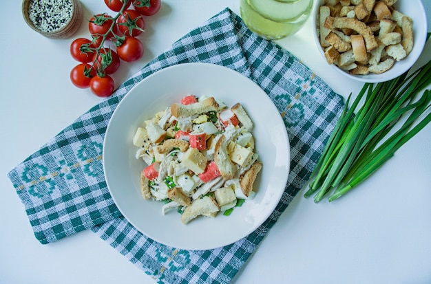 Salade met crackers, krabsticks, kipfilet, verse kruiden en harde kaas