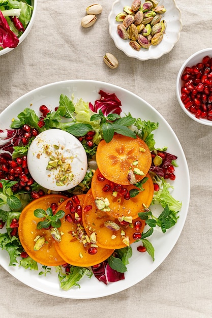 Salade met dadelpruim burrata pomergranat en pistache gezonde voeding bovenaanzicht