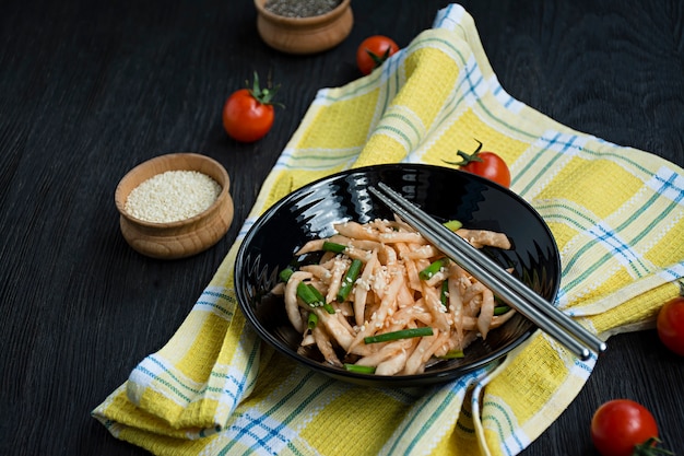 Salade met daikon radijs, groene uien, honing en rode chilipoeder. Aziatische salade. Plat leggen. . Donker