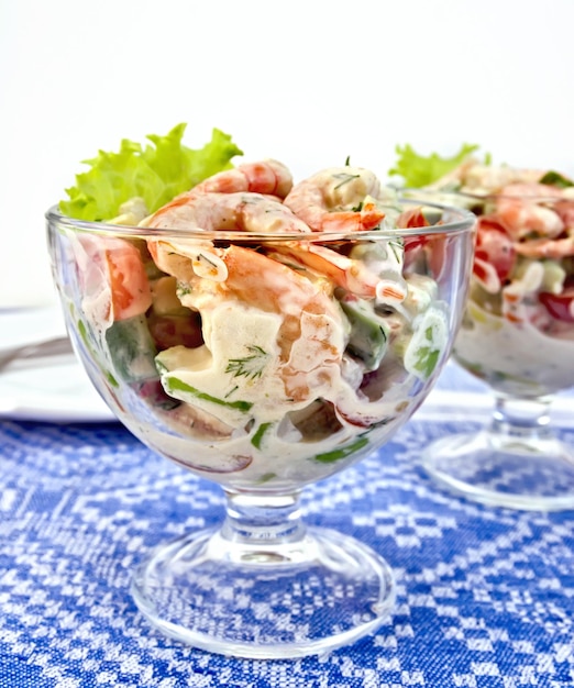 Salade met garnalen en tomaten in glas op tafelkleed