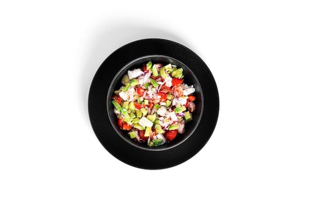 Salade met garnalen, gesneden tomaten, ui en avocado geïsoleerd.