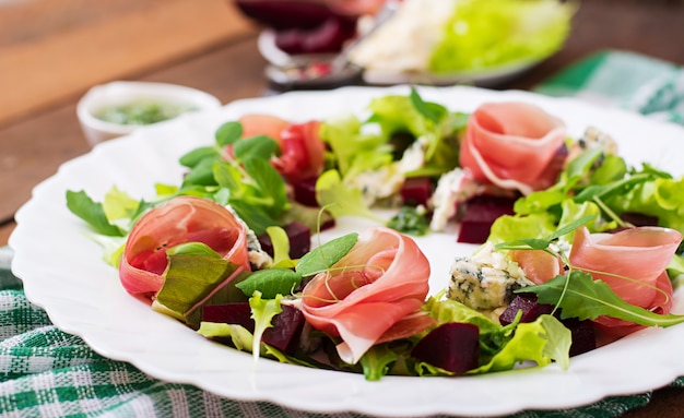 Salade met gebakken bieten, blauwe kaas, ham en groene mix met pesto