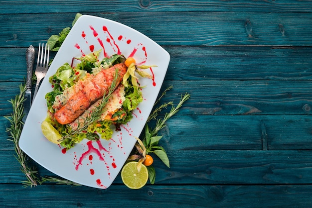 Salade met gebakken zalm en groenten Op een houten ondergrond Bovenaanzicht Copy space