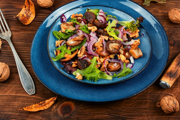 Foto salade met gegrilde boschampignons, uien, kruiden en walnoten concept gezonde voeding rustieke stijl
